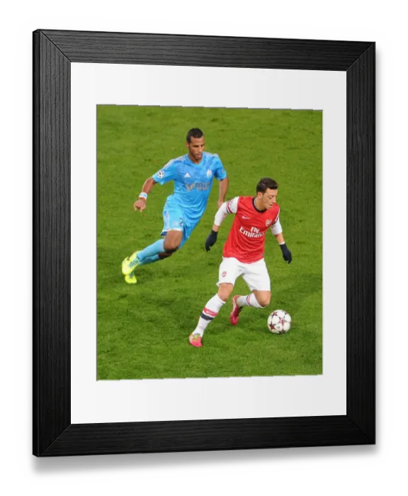 Framed Print : Mesut Ozil vs Alaixys Romao: A Football Rivalry Ignites in the Arsenal vs Marseille UEFA Champions League Clash