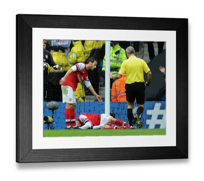 Framed Print : Arsenal's Koscielny Injured as Flamini Waves for Help vs Manchester City (2013-14)