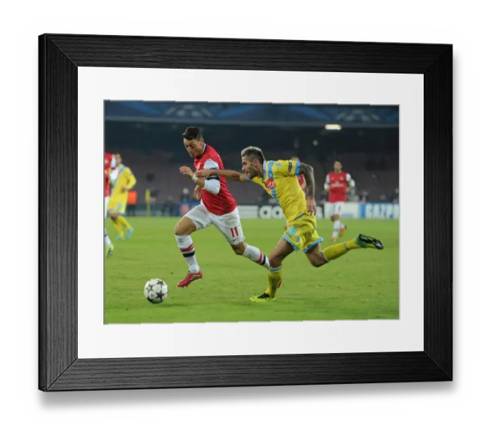 Framed Print : Mesut Ozil vs Valon Behrami: A Battle in the UEFA Champions League between Napoli and Arsenal