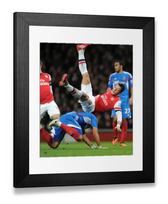 Framed Print : Mesut Ozil vs. Liam Rosenior: A Tenacious Clash at Arsenal's Emirates Stadium (Arsenal vs. Hull City, 2013-14)