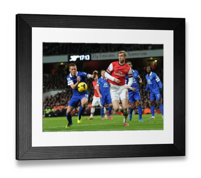 Framed Print : Arsenal's Per Mertesacker Outruns Everton's James McCarthy during Premier League Clash
