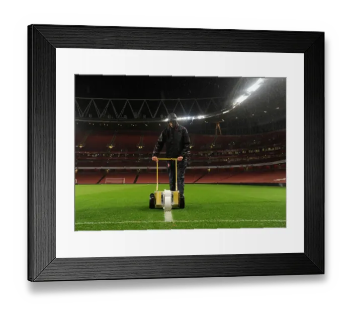 Framed Print : Arsenal's Unyielding Groundsman: Sion Bennett Braves the Rain to Prepare for Arsenal vs. Chelsea Showdown