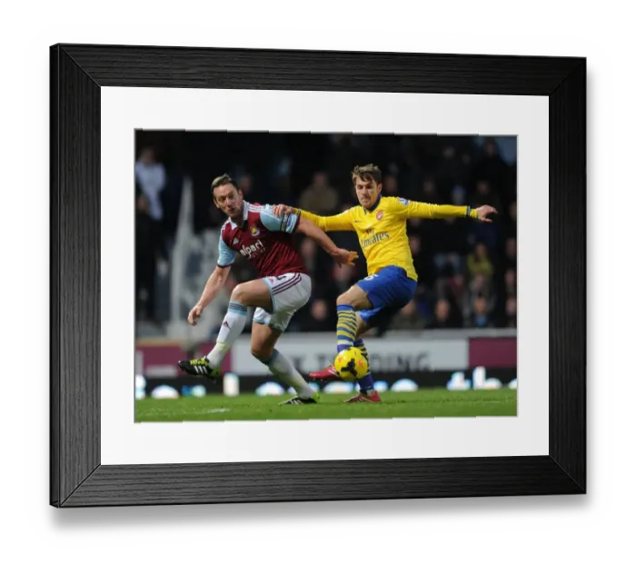 Framed Print : Aaron Ramsey vs. Kevin Nolan: Intense Tackle in West Ham United vs. Arsenal Premier League Clash (2013-14)