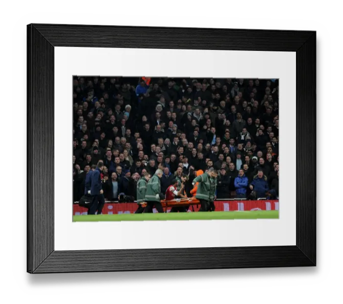 Framed Print : Theo Walcott (Arsenal) is stretchered from the pitch. Arsenal 2: 0 Tottenham Hotspur