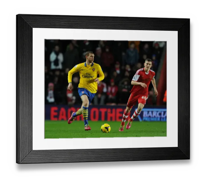 Framed Print : Per Mertesacker vs. Sam Gallagher: Intense Battle at Southampton's St Marys Stadium - Premier League 2013-14