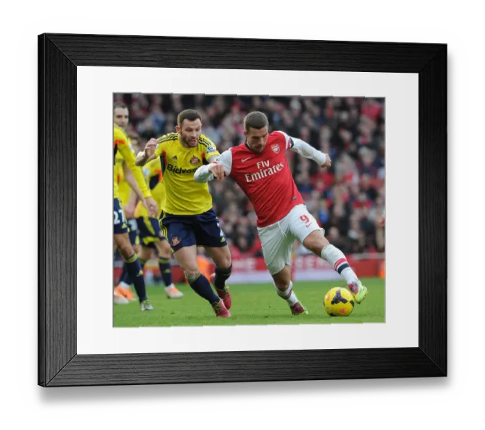 Framed Print : Arsenal's Lukas Podolski Clashes with Sunderland's Phil Bardsley in Premier League Showdown Framed Print : Arsenal's Lukas Podolski Clashes with Sunderland's Phil Bardsley in Premier League Showdown