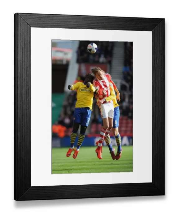Framed Print : Sagna, Mertesacker and Crouch Clash in Stoke City vs Arsenal Premier League Encounter
