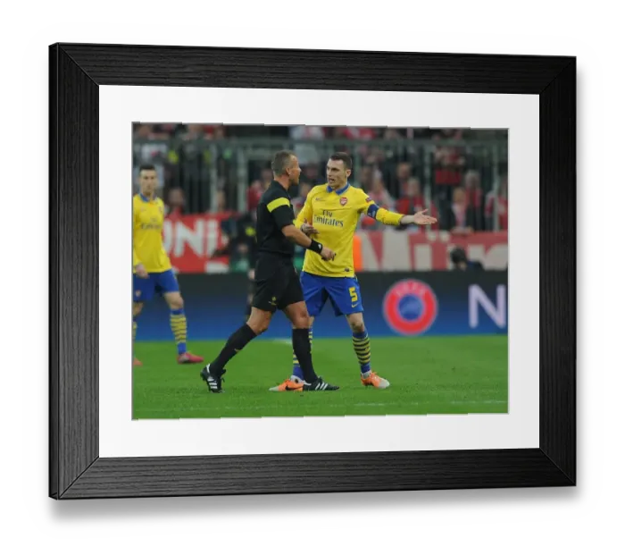 Framed Print : Thomas Vermaelen Confronts Referee Svein Oddvar Moen in Tense Arsenal-Bayern Clash