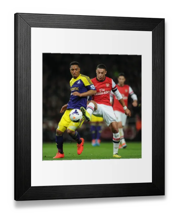 Framed Print : Arsenal's Oxlade-Chamberlain Faces Off Against Swansea's De Guzman Framed Print : Arsenal's Oxlade-Chamberlain Faces Off Against Swansea's De Guzman