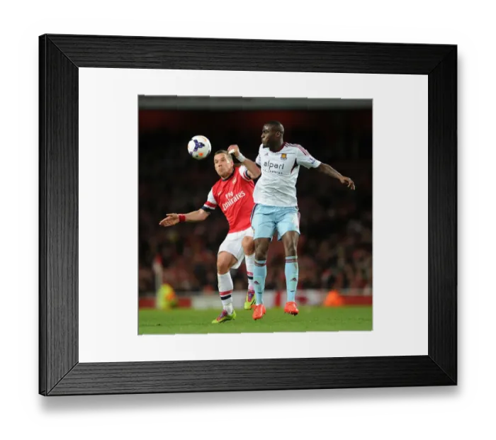 Framed Print : Arsenal vs. West Ham: Podolski vs. Demel - Premier League Clash at Emirates Stadium