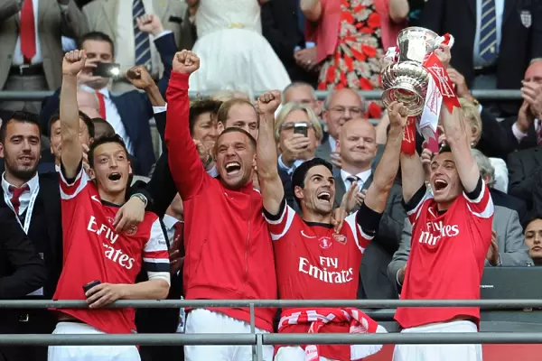 Arsenal Celebrates FA Cup Victory: Ozil, Podolski, Arteta, and Vermaelen Lift the Trophy