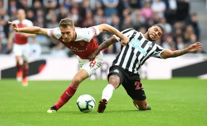 Framed Print : Aaron Ramsey vs Kenedy: Intense Battle in Newcastle United vs Arsenal FC Premier League Clash Framed Print : Aaron Ramsey vs Kenedy: Intense Battle in Newcastle United vs Arsenal FC Premier League Clash