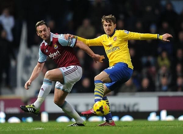 Aaron Ramsey vs. Kevin Nolan: Intense Tackle in West Ham United vs. Arsenal Premier League Clash (2013-14)
