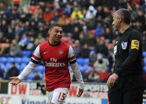 Alex Oxlade-Chamberlain's Light-Hearted Moment: A Humorous Break in the Intense Wigan Athletic vs Arsenal Clash (2012-13) - Arsenal's Star Player Jokes with the Referee's Assistant