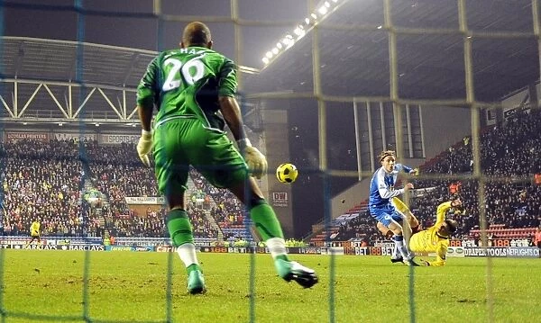 Andrey Arshavin shoots past Wigan defender Ronnie Stam to score the 1st Arsenal