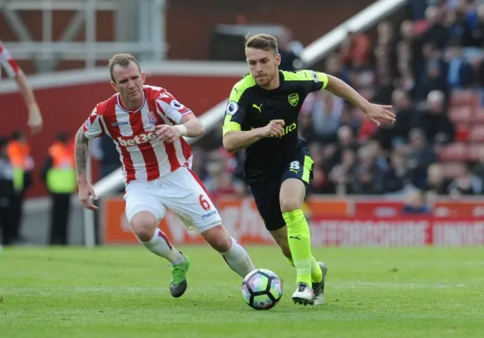 Framed Print : Aron Ramsey vs. Glenn Whelan: Intense Battle in Stoke City vs. Arsenal Premier League Clash