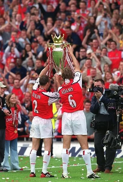 Arsenal captain Tony Adams and Lee Dixon hold the Premiership trophy after the match