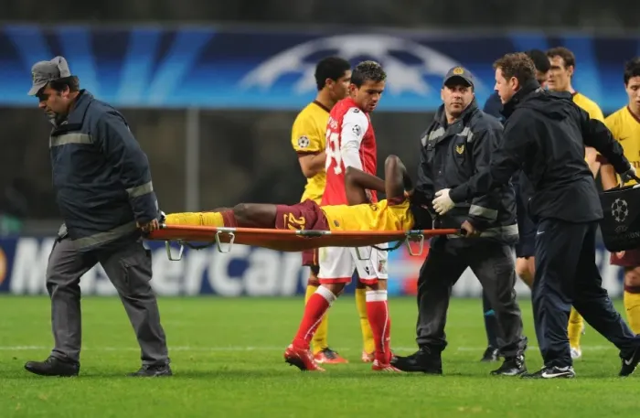 Framed Print : Arsenal defender Emmanuel Eboue is carried off after an injury to his ankle