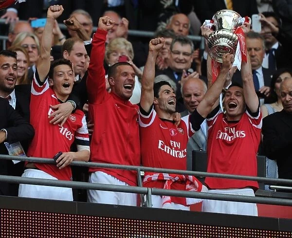 Arsenal FC Celebrates FA Cup Victory: Mesut Ozil, Lukas Podolski, Mikel Arteta, and Thomas Vermaelen Lift the Trophy