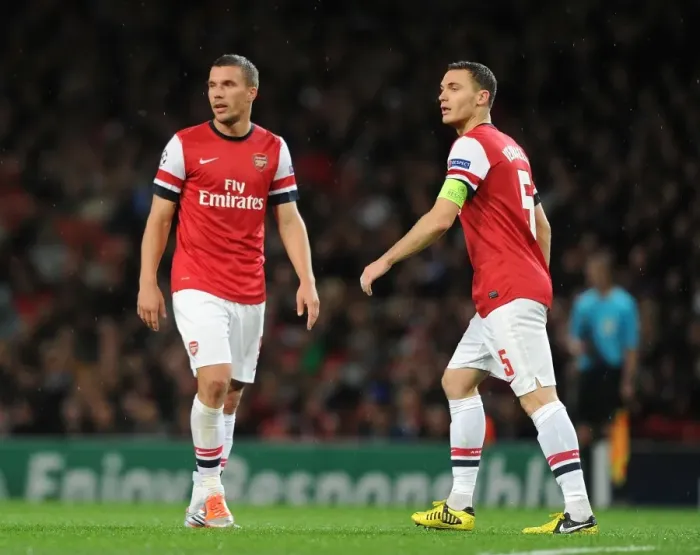 Framed Print : Arsenal FC vs Olympiacos FC: Lukas Podolski and Thomas Vermaelen in Action during the 2012-13 UEFA Champions League Match
