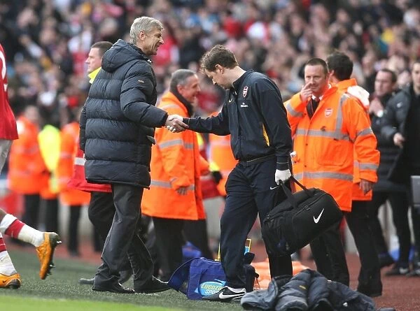 Arsenal manager Arsene Wenger shakes hands with physio Colin Lewin