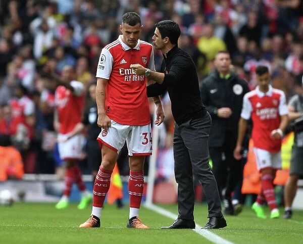 Arsenal Manager Mikel Arteta Consults with Granit Xhaka: Tactical Discussions during Arsenal vs. Tottenham (2022-23)