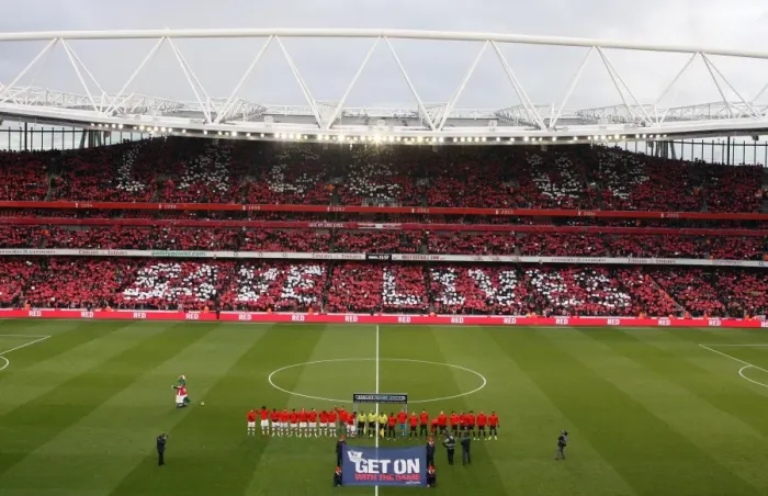 Framed Print : The Arsenal and Manchester United teams walk out onto the pitch with the Nike Lace Up Save Lives cards held up be the fans. Arsenal 1: 3 Manchester United. Barclays Premier League. Emirates Stadium, 31  /  1  /  10. Credit : Arsenal Football Club