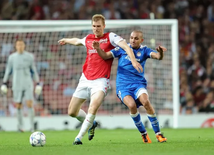 Framed Print : Arsenal Overcomes Olympiacos: Per Mertesacker's Goal Secures 2-1 Victory in UEFA Champions League Group F