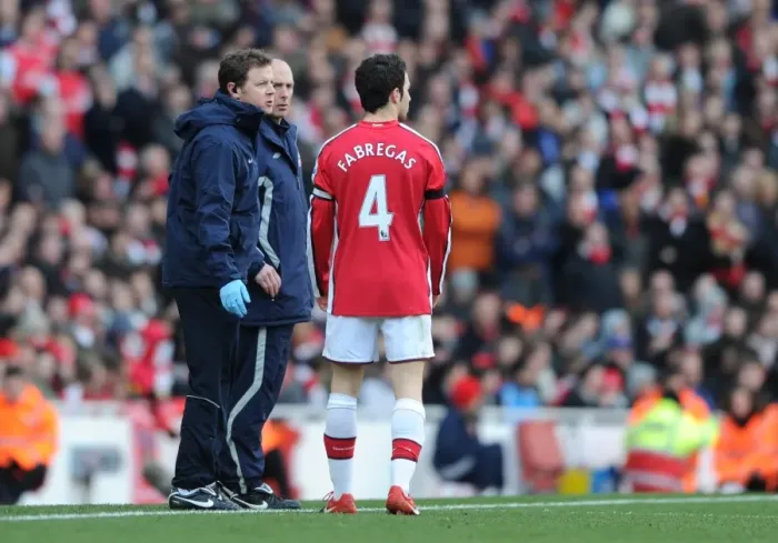 Framed Print : Arsenal physio Colin Lewin talks to captain Cesc Fabregas during the match