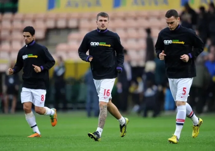 Framed Print : Arsenal Players Aaron Ramsey and Thomas Vermaelen Warm Up in Kick It Out Shirts (Norwich City vs Arsenal, 2012-13)