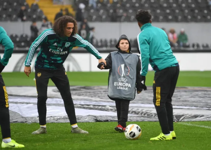 Framed Print : Arsenal Players Engage with Ballboy Before Vitoria Guimaraes Clash in Europa League