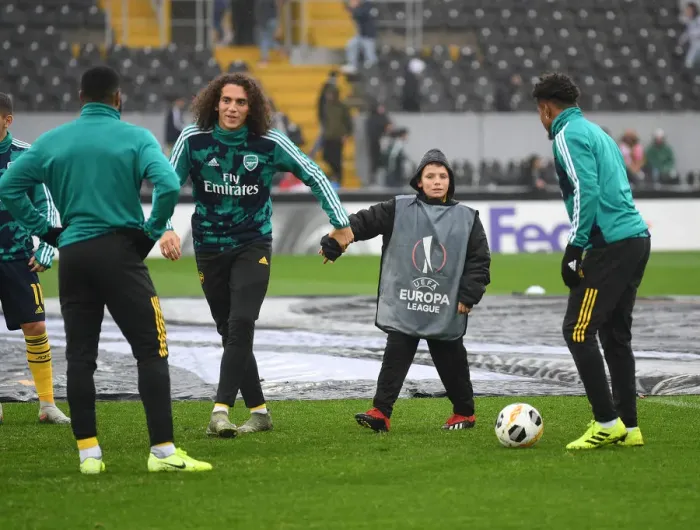 Framed Print : Arsenal Players Engage in Pre-Match Playtime with Ballboy Before Vitoria Guimaraes Clash