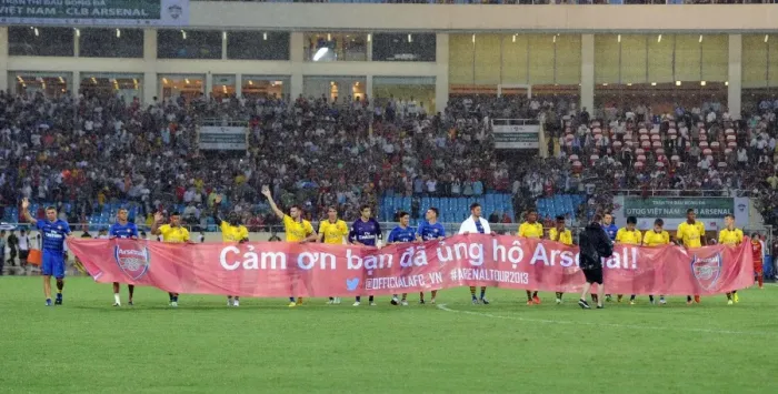 Framed Print : Arsenal Players Honor Vietnamese Fans with Banner at Vietnam Friendly Match, 2013