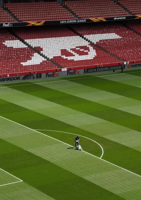 Framed Print : Arsenal: Preparing for Battle - Arsenal Groundsmen Set the Stage for Europa League Semi-Final vs Valencia