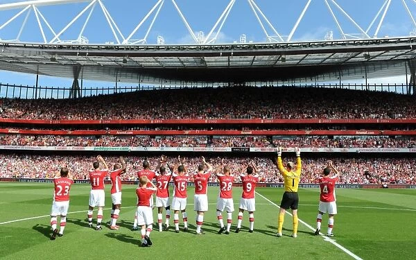 The Arsenal team wave to the fans before the match
