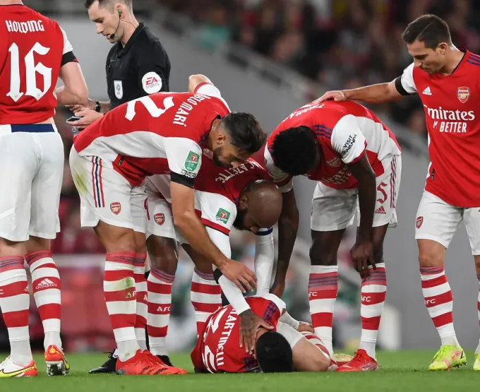Framed Print : Arsenal Tend to Their Injured Star: Martinelli Attended by Lacazette, Mari, and Partey vs AFC Wimbledon (2021-22 Carabao Cup)