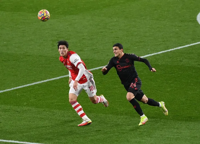 Framed Print : Arsenal vs Southampton: Tomiyasu Chases Elyounoussi in Premier League Clash at Emirates Stadium