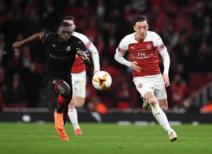 Framed Print : Arsenal vs Stade Rennais: Mesut Ozil Clashes with Hamari Traore in UEFA Europa League Showdown