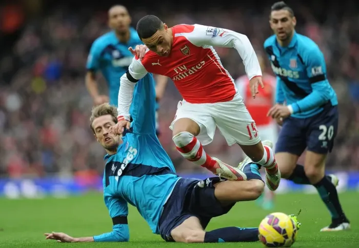 Framed Print : Arsenal vs Stoke City: Oxlade-Chamberlain Tackles Crouch in Intense Premier League Clash