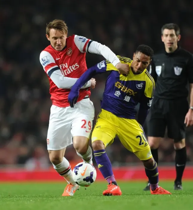 Framed Print : Arsenal vs Swansea: Kallstrom vs De Guzman - Intense Battle in the Premier League