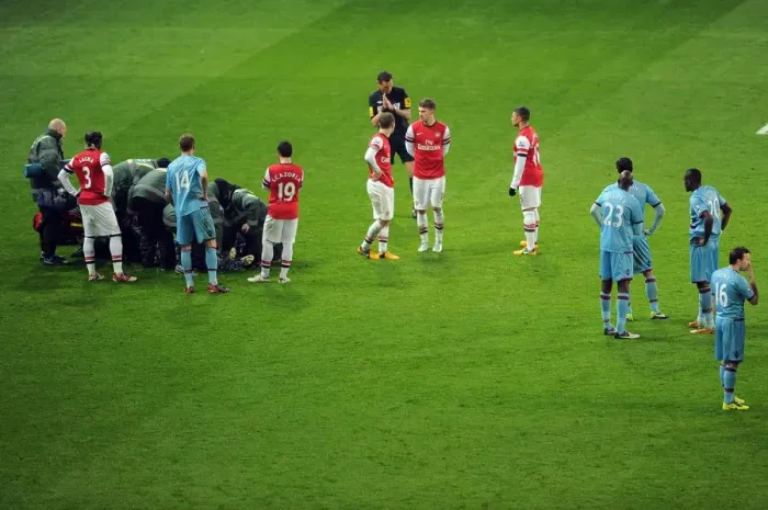 Framed Print : Arsenal and West Ham players wait for Daniel Potts (West Ham) to be treated for an injury Framed Print : Arsenal and West Ham players wait for Daniel Potts (West Ham) to be treated for an injury
