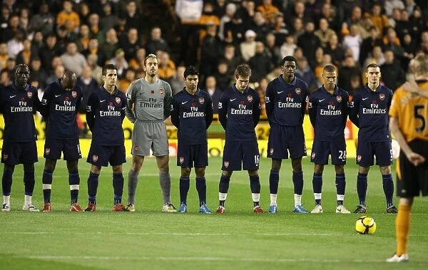 The Arsenal and Wolves teams observe a minutes silence