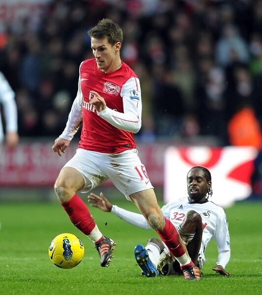 Arsenal's Aaron Ramsey Battles Nathan Dyer of Swansea for Ball Possession in Premier League Clash
