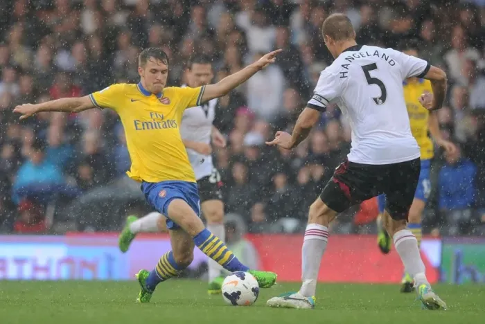Framed Print : Arsenal's Aaron Ramsey Faces Off Against Fulham's Brede Hangeland in Premier League Clash Framed Print : Arsenal's Aaron Ramsey Faces Off Against Fulham's Brede Hangeland in Premier League Clash
