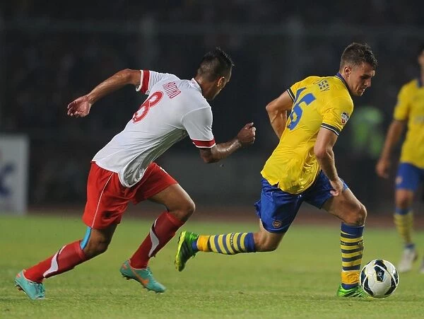 Arsenal's Aaron Ramsey Faces Off Against Raphael Maitimo of Indonesia Dream Team