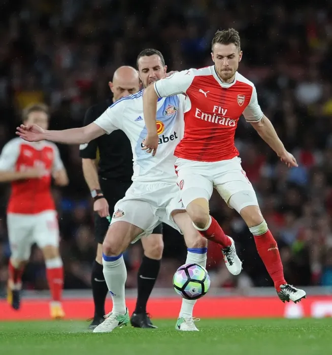 Framed Print : Arsenal's Aaron Ramsey Faces Off Against Sunderland's John O'Shea in Premier League Showdown Framed Print : Arsenal's Aaron Ramsey Faces Off Against Sunderland's John O'Shea in Premier League Showdown