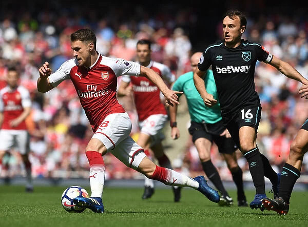 Arsenal's Aaron Ramsey Faces Off Against West Ham's Mark Noble in Premier League Clash