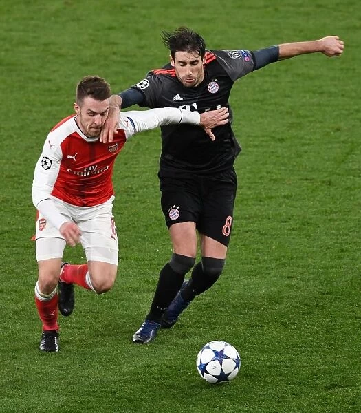 Arsenal's Aaron Ramsey Fends Off Bayern Munich's Javi Martinez in UEFA Champions League Clash