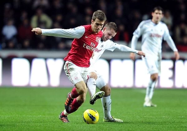 Arsenal's Aaron Ramsey Fends Off Gylfi Sigurdsson's Challenge During Swansea Clash