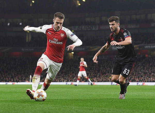 Arsenal's Aaron Ramsey Outmaneuvers AC Milan's Patrick Cutrone in Europa League Clash